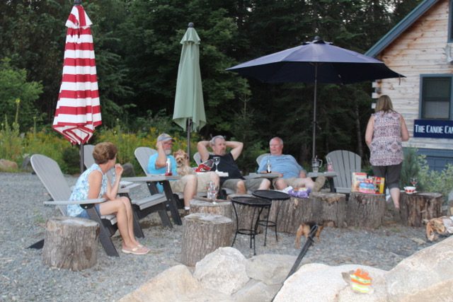 People enjoying a relaxed outdoor gathering around a fire pit.