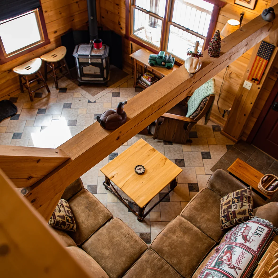 Cozy living room with wooden interior and large windows.